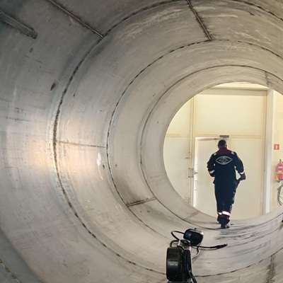 Worker inside a silo with MEKTAL logo on back